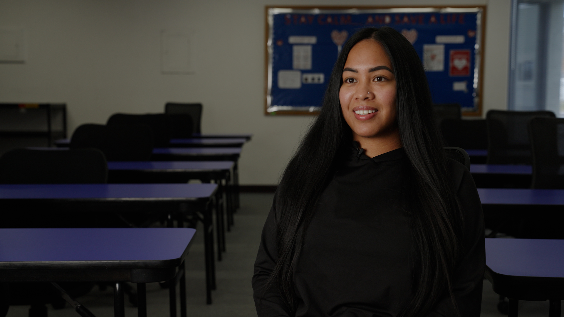 Tiani Luna,wears a black top, sitting inside a classroom